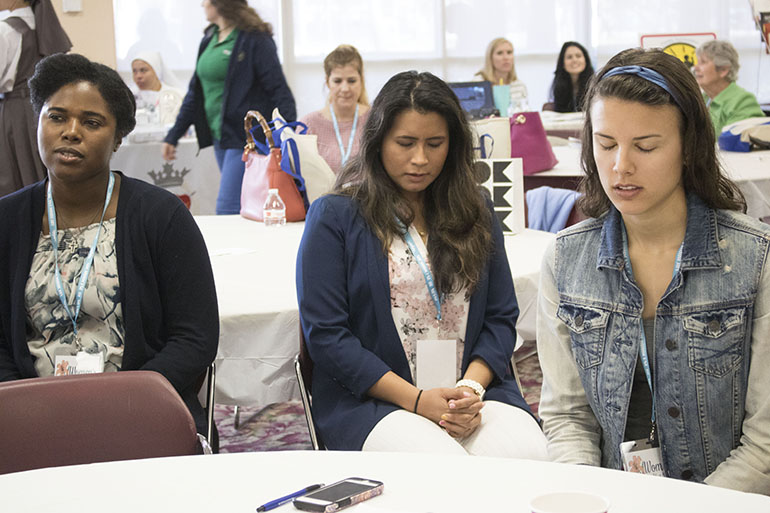 Participants Rachael Sosu, Johana Jesteadt, and Francesca Rieth participate in a moment of meditation during the Women’s Health and Fertility Seminar at St. Thomas University Feb. 24.