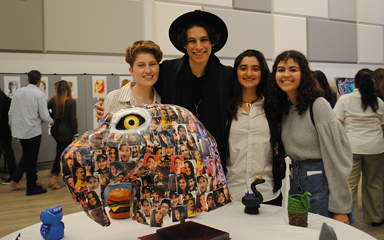 St. Brendan art students Nicole Nader, Gustavo Leon, Isabel Yamin, and Lena Phillips stand next to their installation, a plaster eagle's head dedicated to Marjory Stoneman Douglas shooting victims. Not pictured is fellow artist Laura Barbeite. Their work was displayed at the school's annual Gallery Night March 1.