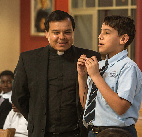 Samuel Garcia, 12, a St. Michael sixth grader, asks a question as Vocations Director Father Elivis Gonzalez looks on during the Focus 11 vocations rally March 1 at St. Agatha Church, Miami.