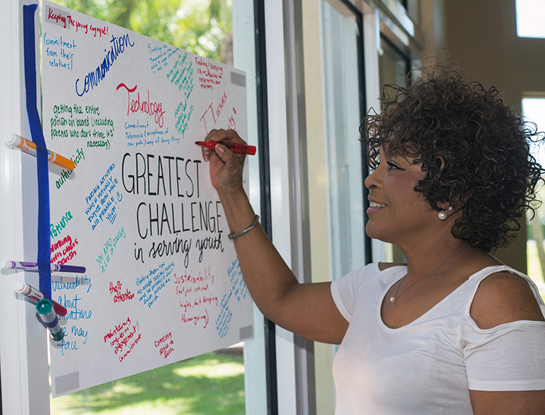 Monique Delancy, of Holy Redeemer Church in Liberty City, fills in her answer to "Greatest Challenges In Serving Youth" during the Archdiocese of Miami Youth Ministry Summit, held March 3 at Msgr. Edward Pace High School.