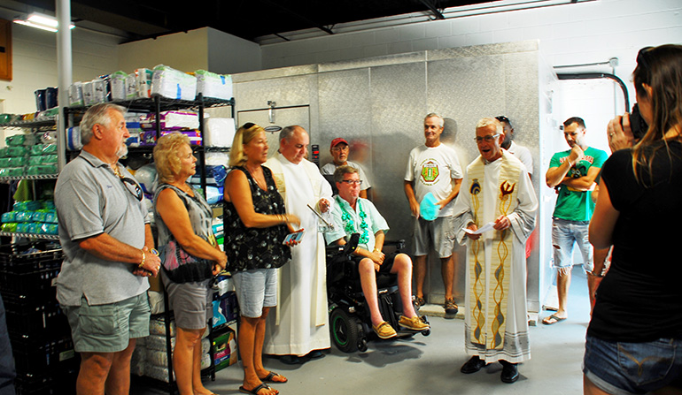 Father John Baker, rector of the Basilica of St. Mary Star of the Sea, Key West, blesses and rededicates the Star of the Sea Outreach Mission on Stock Island March 17, 2018. The mission's facility lost its roof during hurricane Irma. It was rebuilt with financial help from the Knights of Columbus.