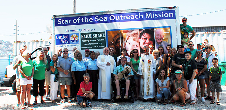 Parishioners and priest of the Basilica of St. Mary Star of the Sea pose with Knights of Columbus representatives, supporters and staff after the March 17, 2018 rededication of the SOS Outreach Mission's building, which was damaged by hurricane Irma last September.