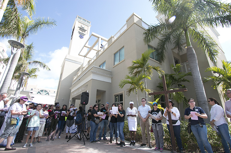 Participants pray at the 14th and final station, outside Camillus House.