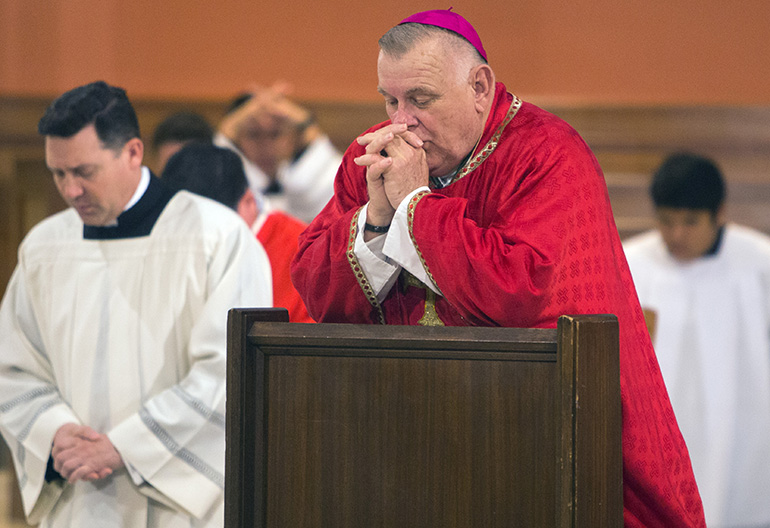 Archbishop Thomas Wenski prays during the Good Friday service, March 30, 2018, at St. Mary Cathedral.