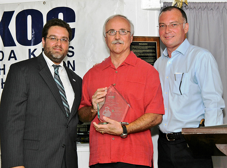 Deacon Richard Turcotte, center, is honored in 2013 by the Florida Keys Outreach Coalition for his service to the homeless and needy in Monroe County. Presenting him with the "Capt'n" Kidd Humanitarian Award are FKOC Chairman Sam Kaufman, left, and Rev. Stephen Braddock, CEO.
