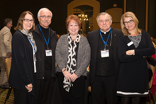 Archbishop Thomas Wenski poses with the staff of Catholic Charities agencies in Miami and St. Augustine dioceses, including Deacon Richard Turcotte, director of Catholic Charities for the Archdiocese of Miami, second from left; Laura Hickey, center, director of Catholic Charities for the Diocese of St. Augustine; and Michelle Karolak, far right, director of Refugee Resettlement Services for Catholic Charities in St. Augustine. All took part in the 2015 Refugee Services Consultation sponsored by the Florida Department of Children and Families.