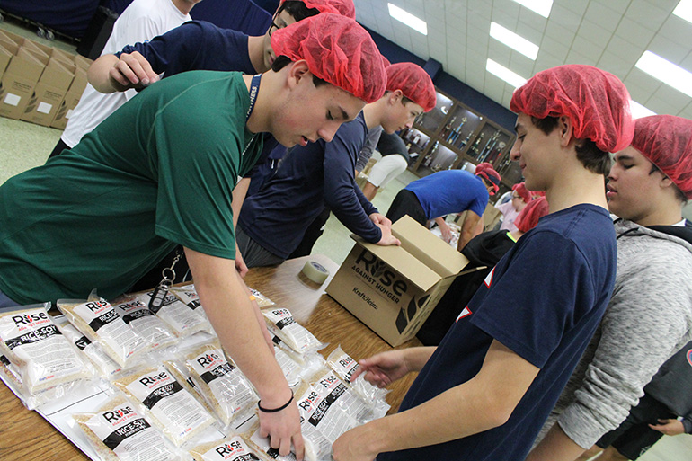 Columbus students organize meals bags before they are packed into boxes.