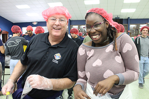 Knight of Columbus Paul McCaffrey poses with Carrollton School of the Sacred Heart sophomore Amber Johnson. The Knights were instrumental in raising the funds for the Helping Hands event.