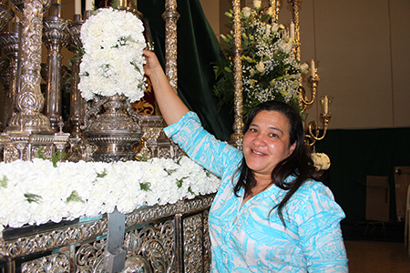 María Pérez, feligresa de la parroquia Corpus Christi, decora con flores el anda de la Virgen de la Macarena que saldrá en procesión la noche del Viernes Santo.