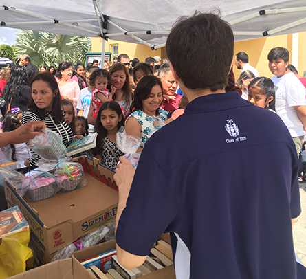 Andrés alfonso, alumno de décimo grado del Colegio Belén entrega a los niños de la Misión Santa Ana los libros que recolectaron con sus compañeros del Colegio de Belén.