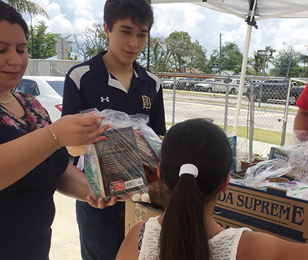 Mar&iacute;a Serrano, recepcionista de la Misi&oacute;n Santa Ana y Andr&eacute;s Alfonso, alumno del Colegio de Bel&eacute;n y promotor de la recolecci&oacute;n de libros reparten las bolsitas confeccionadas con dulces y libros a los ni&ntilde;os que asistieron a la Misa el Domingo de Resurrecci&oacute;n.