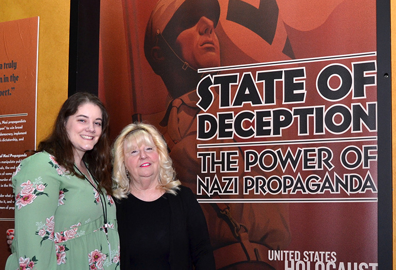 Rositta Kenigsberg, right, director of the Holocaust Documentation and Education Center, shows the opening panel of the "State of Deception" exhibit on Nazi propaganda. With her is Erin Cohen, educational coordinator.