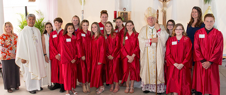 Archbishop Thomas Wenski poses with the confirmation class from St. Peter Church in Big Pine Key after presiding at the Mass and confirmation ceremony April 4. At left is Father Jesus "Jets" Medina, St. Peter's administrator.