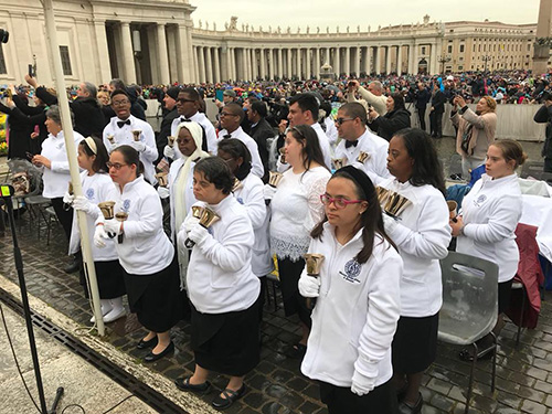 Los miembros del Coro de Campanas del Marian Center esperan el inicio de su presentación en la Plaza de San Pedro, el 4 de abril.