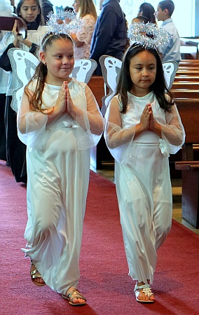 Students Aubrey Sabillon and Alanis Gamarra dress as angels for a Mother's Day Mass at St. Michael the Archangel. Both attend St. Michael's School.