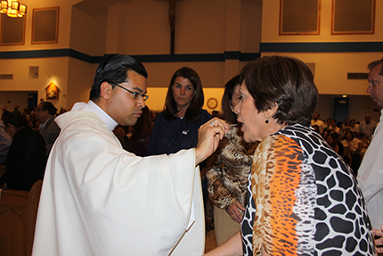 Father Yamil Miranda, parochial vicar at Blessed Trinity in Miami Springs, gives Communion to María Elena Calleja during the Mass for peace and justice in Nicaragua that was celebrated at Our lady Divine Providence in Sweetwater, the city with the highest concentration of Nicaraguans in South Florida.