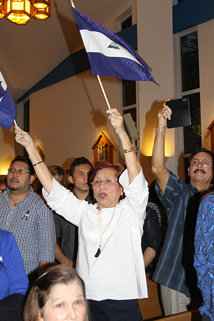 Soveida Macrea de Zúñiga waves two Nicaraguan flags after the Mass for peace in that country. Macrea has lived in the U.S. since 1989, when earlier political conflicts caused her to leave her homeland.