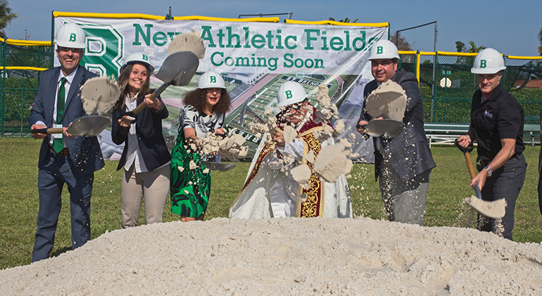 Breaking ground for the new sports complex at St. Brendan High School in Miami April 27, from left: Jose Rodelgo-Bueno, principal; Julia Zayas, 18, a senior and the high school's Executive Board president; Kim Pryzbylski, archdiocesan superintendent of schools; Auxiliary Bishop Enrique Delgado; David Prada, archdiocesan director of Building and Property; and Greg Galmin, vice president of Burke Construction.