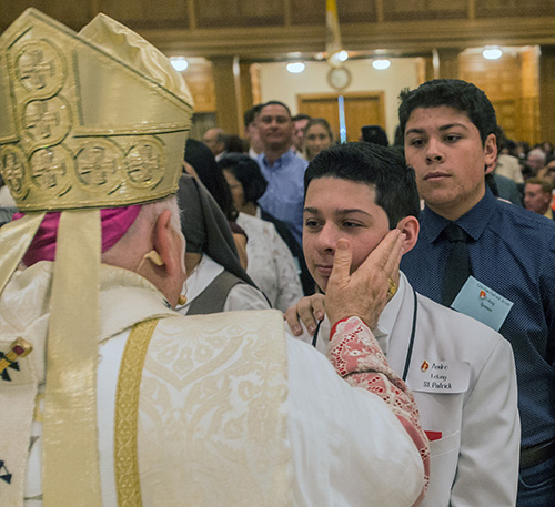 Archbishop Thomas Wenski confirms Andre Lelong during the second of two Rite of Reception ceremonies April 29 at St. Mary Cathedral.