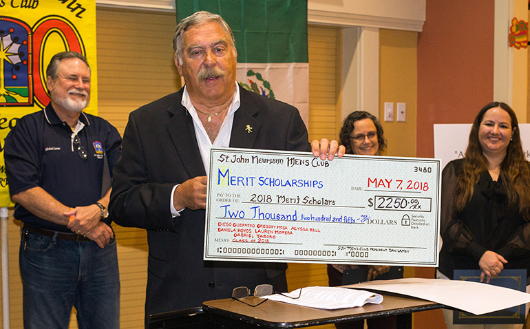 Eric Schwindemann, chair of St. John Neumann Men's Club merit scholarship committee, holds up a copy of the scholarship check.
The St. John Neumann Men's Club awarded merit scholarships to six students - three entering high school, three entering college - at their annual Cinco de Mayo dinner, held May 7.