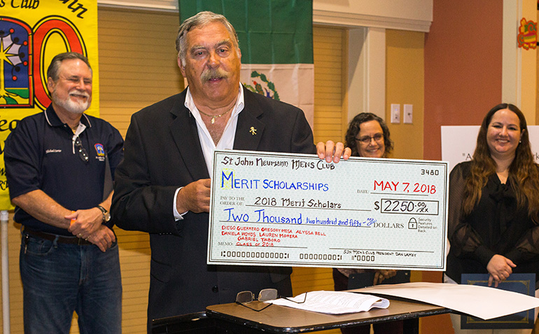 Eric Schwindemann, chair of St. John Neumann Men's Club merit scholarship committee, holds up a copy of the scholarship check.
The St. John Neumann Men's Club awarded merit scholarships to six students - three entering high school, three entering college - at their annual Cinco de Mayo dinner, held May 7.