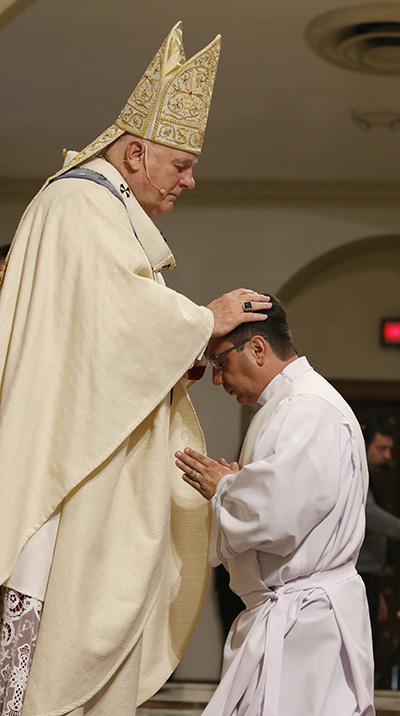 El Arzobispo Thomas Wenski impone las manos al diácono Omar Ayubi, llamando al Espíritu Santo y ordenándolo como "sacerdote para siempre".