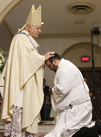 El Arzobispo Thomas Wenski impone las manos al diácono Matthew Gómez, llamando al Espíritu Santo y ordenándolo como "sacerdote para siempre".