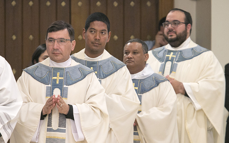 Newly ordained priests return to take their place in the sanctuary after having their hands anointed with oil of chrism. From left: Fathers Omar Ayubi, Juan Alberto Gomez, Gustavo Barros and Matthew Gomez.