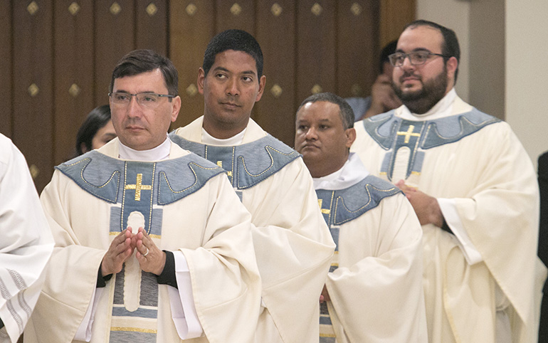 Los sacerdotes recién ordenados regresan para ocupar su lugar en el santuario después de haber sido ungidos con el aceite del Crisma. Desde la izquierda: El P. Omar Ayubi, el P. Juan Alberto Gómez, el P. Gustavo Barros y el P. Matthew Gómez.