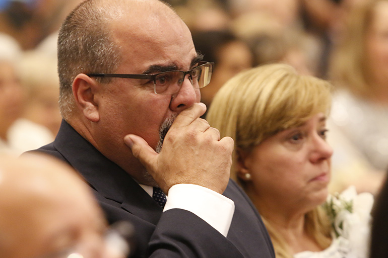 Fernando Gomez tries to control his emotions as he witnesses the ordination of his son, Father Matthew Gomez. Next to him is his also teary-eyed wife, Laura Gomez.