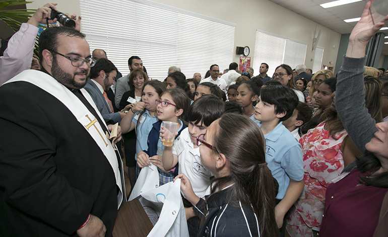 At the cathedral hall after the ceremony, Father Matthew Gomez speaks with fifth-graders from St. Bonaventure School in Davie, who "adopted" him as a seminarian.