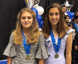 Giselle Linares and Carolina Juara of St. Theresa Catholic School show the medals they won in Duke University's Talent Identification Program.