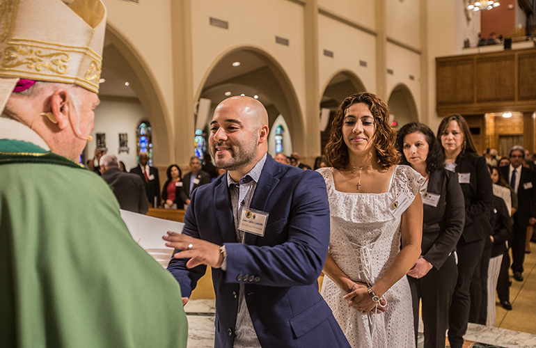 Juan Carlos Londono, of St. Bartholomew Parish in Miramar, receives his certificate during the commissioning Mass, June 9 at St. Mary Cathedral.