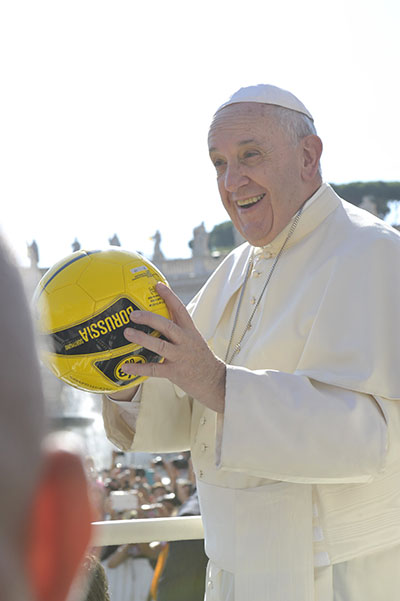 Pope Francis holds a soccer ball in St. Peter's Square during the Wednesday general audience on August 26, 2015. "Giving the Best of Yourself," a document released June 1 by the Dicastery for Laity, the Family and Life, is the first Vatican document on sports.