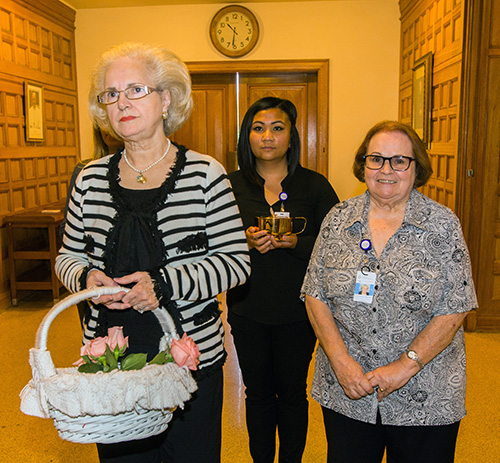 From left, Martha Rodriguez de Perez prepares to bring up the offertory with Catholic Hospice's Gian Santayana, center, bereavement coordinator, and Luz Suarez Macias, bereavement counselor.