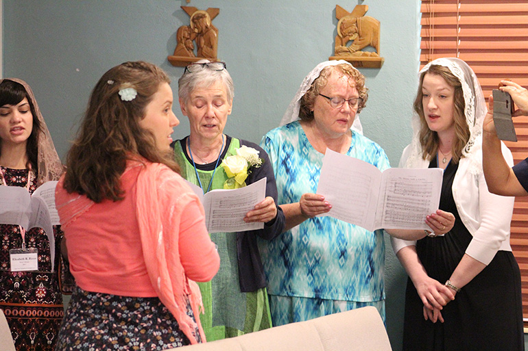 La cantante y directora de canto, Claire Halbur, vestida de rosado, dirige un pequeño coro de vírgenes consagradas durante la Misa del 8 de julio, en el Centro de Renovación MorningStar, en Pinecrest.