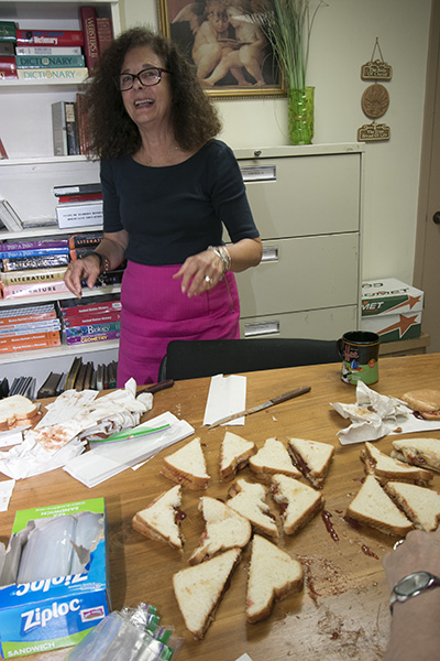 Kim Pryzbylski, superintendent of schools, does her job: cutting the peanut butter and jelly sandwiches into halves.