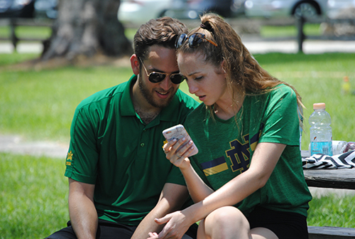 Among the participants at the Champions Challenge were married couples. Here, A.J. and Melissa Tablada, members of the Fiat marriage group for young adults, check their phone during a break.