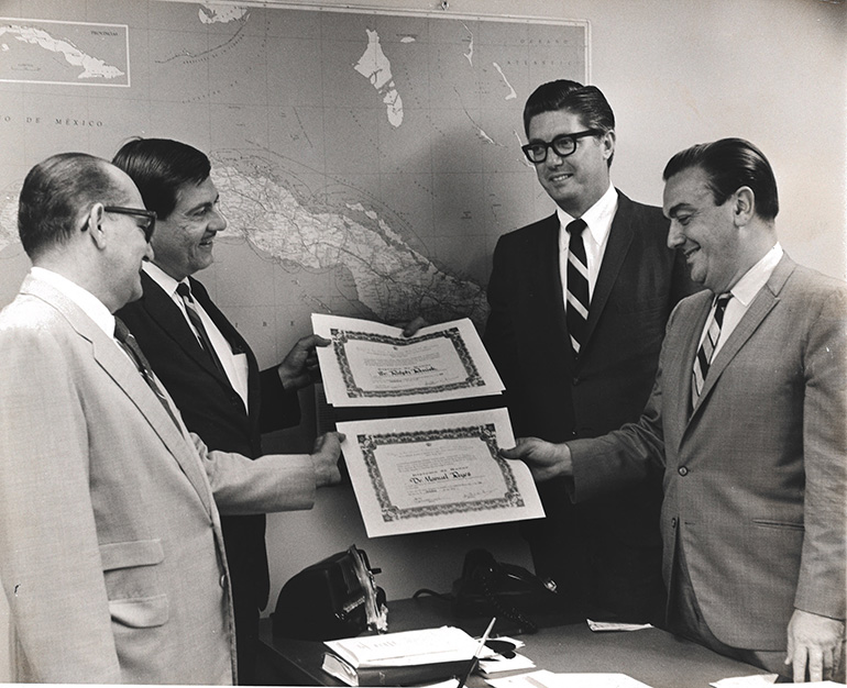 El editor de Latin American News del Canal 4, Manolo Reyes, a la derecha, aparece aquí con Ralph Renick, vicepresidente de noticias de WTVJ, recibiendo certificados de reconocimiento de parte de oficiales de la Asociación Cubana de Periodismo Anticomunista. (FOTO DE ARCHIVO)