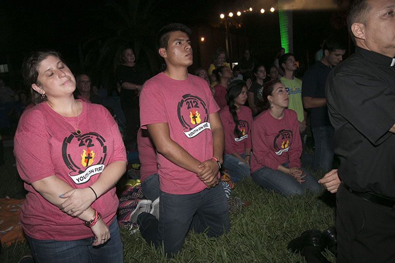 Members of St. Joseph Parish's Youth on Fire pray during adoration of the Blessed Sacrament at the Aug. 22 prayer vigil at St. John Vianney College Seminary.
