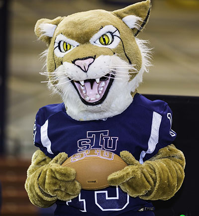 St. Thomas University's Bobcat mascot holds the football after the announcement that the archdiocesan university will field a football team in 2019. The Bobcats will play in the Mid-South Conference of the National Association of Intercollegiate Athletics.