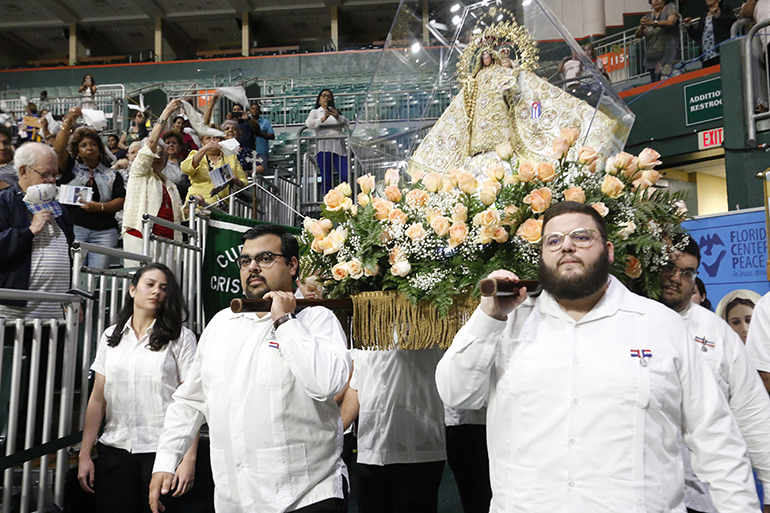 Los miembros de Encuentros Juveniles cargan la imagen de Nuestra Señora de la Caridad durante la procesión antes de la Misa en su día de fiesta.