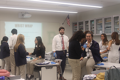 Estudiantes de 11vo. grado practican como entablillar dedos en su clase de primeros auxilios.