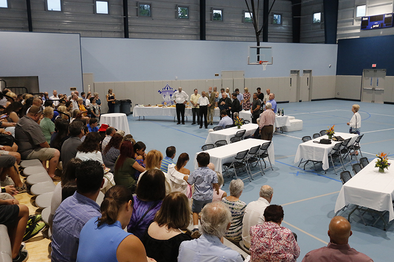Parishioners, parents and students of The Basilica School of St. Mary Star of the Sea pray in the new gym and multipurpose building, known as the Rose Renna Activity Center, as Archbishop Thomas Wenski blesses and dedicates it.