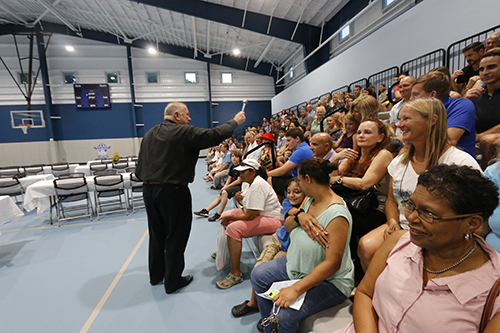 Archbishop Thomas Wenski sprinkles holy water on parishioners, parents and students of The Basilica School of St. Mary Star of the Sea during the Sept. 15 blessing and dedication of the new gym and multipurpose building, known as the Rose Renna Activity Center.