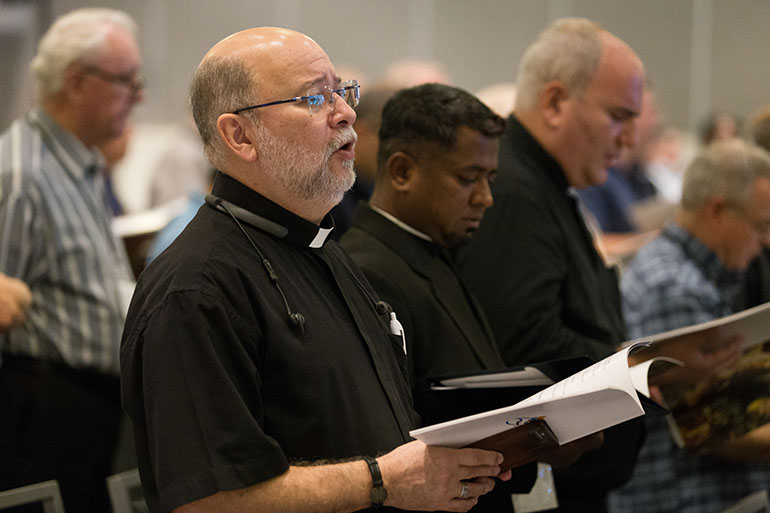 Archdiocesan priests sing evening prayers Sept. 18 at the opening of an annual clergy convocation being held at the Hilton Miami Downtown.