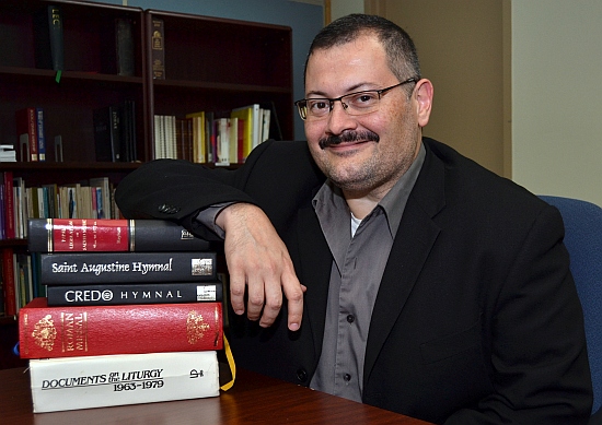 Gustavo Zayas, music director for the archdiocese, literally leans on historical guides in assessing music.