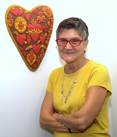 Artist Angi Curreri poses with her ceramic sculpture "Heart of Hearts," part of her "Small Offerings" exhibit at St. Thomas University.