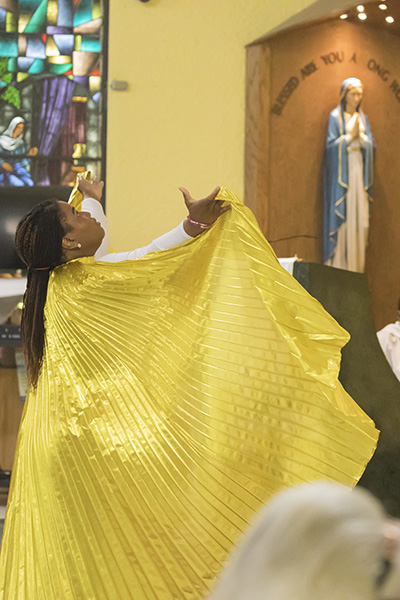 Sterleen Romain, member of St. Helen's Praise Dancers, leads a moment of praise during the Mass celebrating the parish's 50th anniversary. The praise dancers are members of the church's LifeTeen ministry.