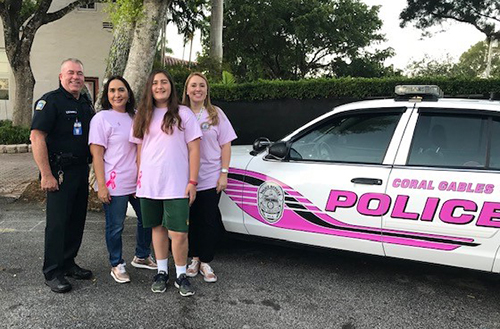 From left: Officer Robert Alonso of the Coral Gables Police Department with Monica Cejas, Anabelle Cejas and Cristina Guanche-Martinez pose with the Breast Cancer Awareness Pink Police Car.